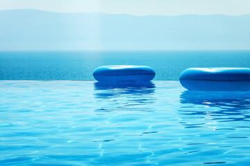 Obraz na płótnie Canvas Infinity swimming pool with sea and Mountain View