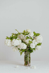 White spring flowers in a vase on the table.