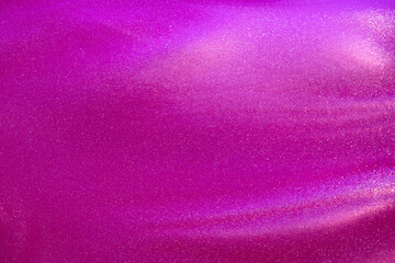 Abstract strains of silver particles in a pink liquid.