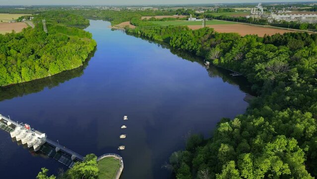 Extremely beautiful river through green Springtime landscape, moving aerial view.
