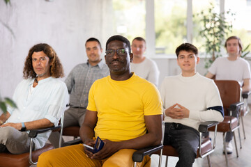 Group of men in the audience attentively listens to a lecture on same-sex relationships