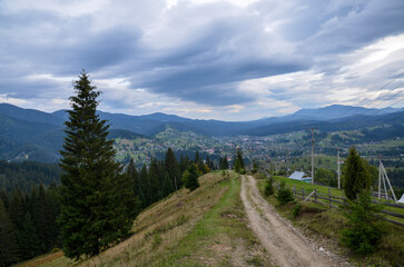 Beautiful landscape with forested hills and Carpathian village in the valley. Carpathian mountains in summer
