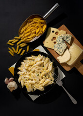 Homemade Italian four cheese pasta with parsley on a black background