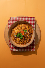 Bolognese pasta on colorful background top view