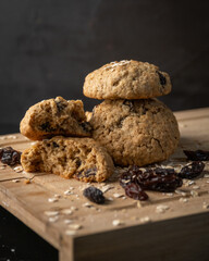 Oatmeal, cinnamon and raisins cookies on a wooden board with a dark background