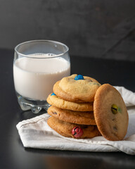 Homemade M&Ms cookies served with a glass of milk