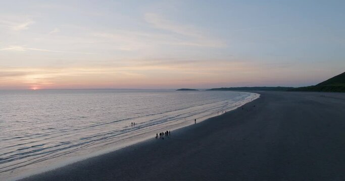 People On The Beach Children In The Water And Fishing At Sunset