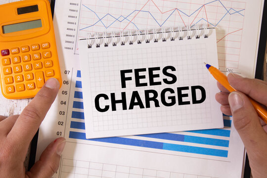 FEES CHARGED text on notebook with clipboard and calculator on chart background. - Powered by Adobe