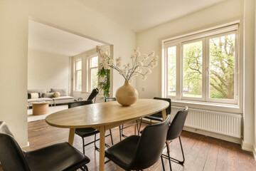 a dining room with chairs and a table in front of a large window looking out onto the trees outside on a sunny day