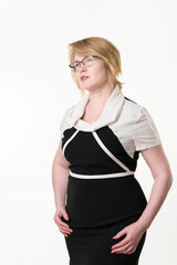 Serious and confident businesswoman in glasses well dressed in black-white dress looking away