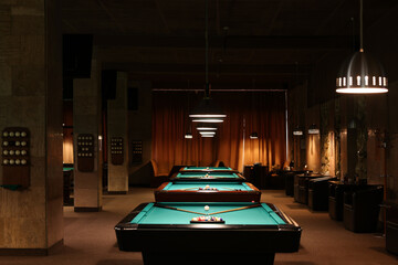 Billiard tables with balls and cues in club