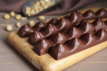 Board with tasty chocolate bars on wooden table, closeup