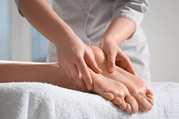 Fototapeta na wymiar Woman receiving feet massage in spa salon, closeup