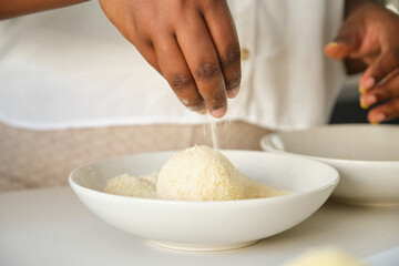 Close up of cuban woman hands breading mashed potatoes balls to prepare cuban style stuffed potatoes.