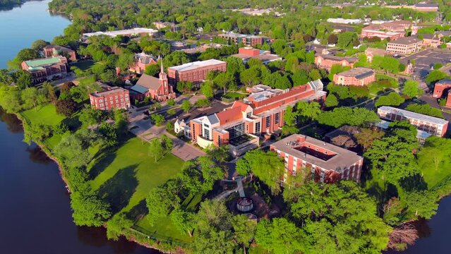 Lush green landscape on the riverfront amid a Springtime morning, moving, aerial view.
