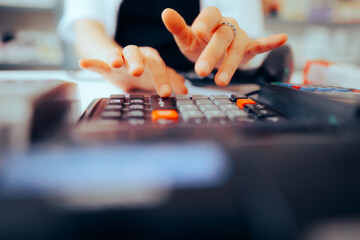 Obraz na płótnie Canvas Hands of a Salesperson Using Cash Register at Work. Cashier registering transaction on her electronic device 