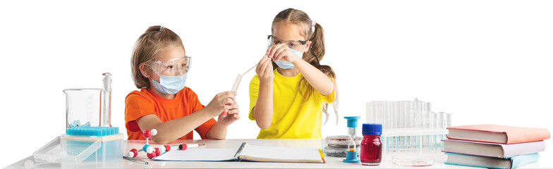 Kids in glasses pouring liquid into flask while conducting experiment with colorful reagents during...