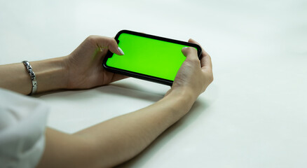 Green screen smartphone. Woman using mobile phone blank green screen horizon view for your advertising copy space and text. Technology and business.