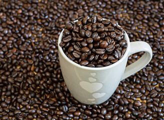 Whole grains of coffee beans are placed in a cup in the upper corner before grinding to drink.