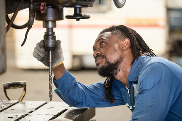 Male african american workers wear yellow hard hat working on repairing factory machinery. Man...