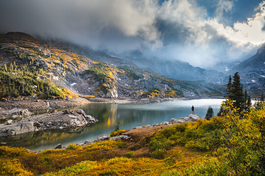 A man standing on the shore of Lake Isabelle, Indian Peaks Wilderness, Colorado