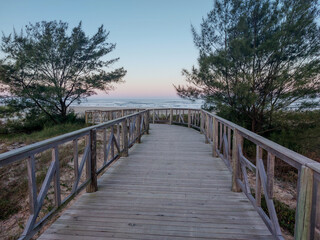 Fototapeta na wymiar Wooden walkway leading to the beach at sunset in summer