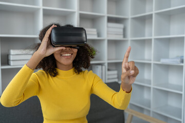 Stylish cheerful african american woman in vr headset spread arms and smiling while dancing and raising fingers in cyberspace. Metaverse vr future girl concept.