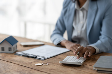 Real estate agent, American businesswoman Africans use calculators to offer mortgages to their clients when deciding to insure their homes and land. Home mortgage and insurance finance concepts.