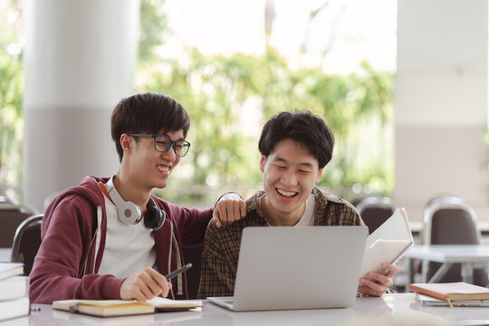 A group of diverse, multiracial young Asian university students are seen brainstorming and discussing together at a meeting. This depicts the concepts of technology and teamwork.