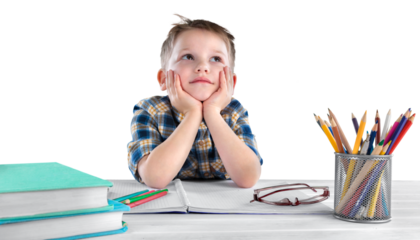 Happy child writing in a notebook in the classroom