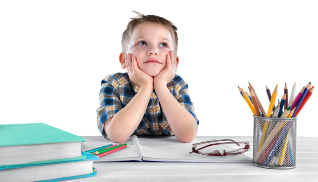 Happy child writing in a notebook in the classroom