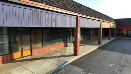 Empty, desolate, deserted shopping outlets theme. Close up aerial view of abandoned retail space in USA.