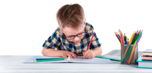 Happy child writing in a notebook in the classroom