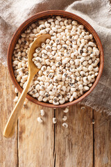 Black eyed peas background with wooden spoon closeup. Vertical top view from above