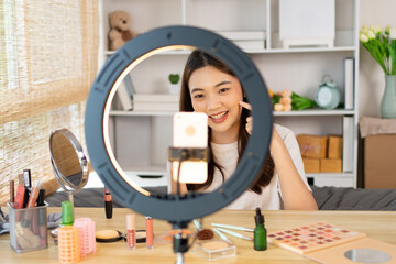 Beautiful woman with a social media influence is greeting the audience for recording vlog video live streaming, Showing how to make up and use cosmetics, Online business on concept of beauty bloggers.