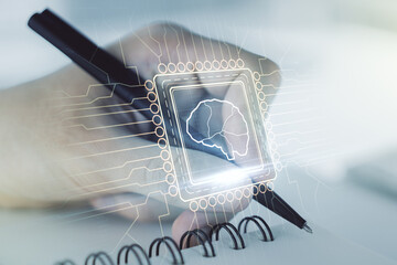 Creative artificial Intelligence concept with human brain hologram and man hand writing in notebook on background. Multiexposure