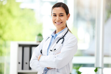 Portrait, medicine and arms crossed with a doctor woman in the hospital for insurance or treatment. Healthcare, happy or smile with a young female medical professional standing alone in a clinic