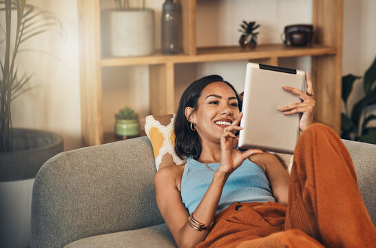 Woman relax on couch with tablet, online streaming with internet and reading ebook or watching film at home. Happy female person with technology, subscription and mobile app with break in living room