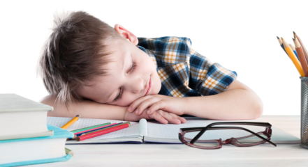 Happy child writing in a notebook in the classroom