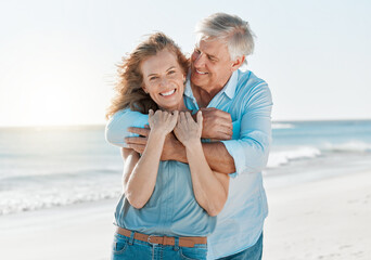 Fototapeta na wymiar Senior, couple and portrait hug by the ocean with happiness and love on holiday in the outdoor. Mature, man and woman at the beach hugging on vacation with smile for travel together with sunshine.