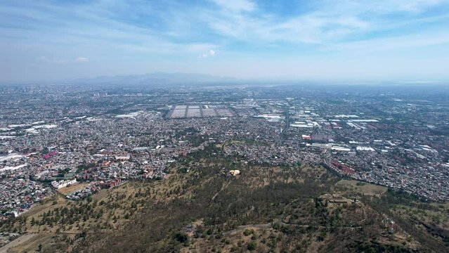 backwards drone shot of east Mexico city over cerro de la estrella in iztapalapa