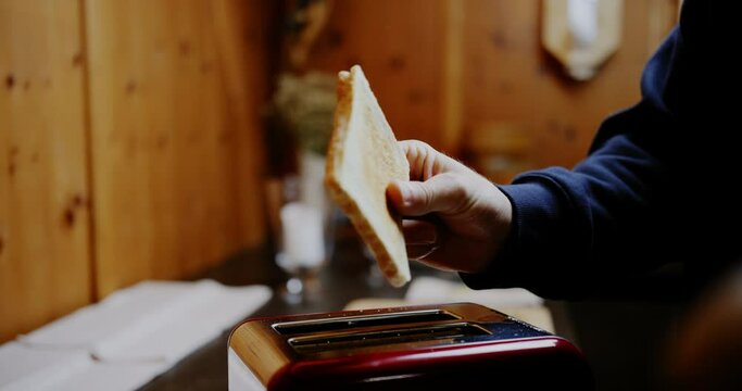 Hand catches perfectly brown toasted white bread popping up out of toaster, pan reveal