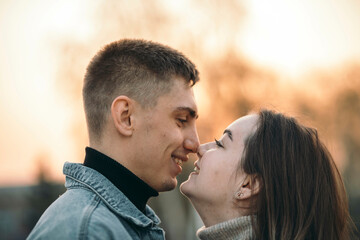 Close up of a smiling beautiful young couple in park at the sunset, happy lifestyle concept