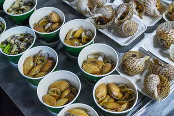 Vietnamese stewed seashells in sauce in the night market on food festival
