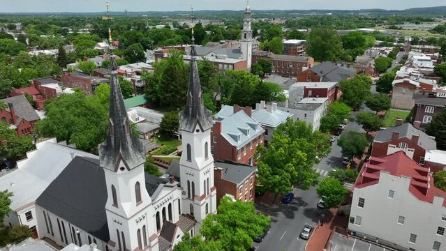 Frederick Maryland. Aerial drone flight between steeples with weather vanes. Historic downtown town view.