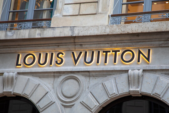 louis vuitton logo chain and sign text facade entrance store fashion brand clothes shop in street