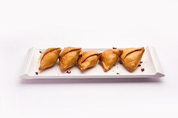 Indian sweet samosa is a Fried pastry soaked in sugar syrup filled with coconut, nuts and fruits