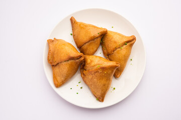 Indian sweet samosa is a Fried pastry soaked in sugar syrup filled with coconut, nuts and fruits