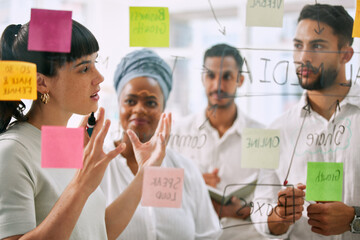 Teamwork, planning and business people on glass for brainstorming, workflow or meeting of marketing goals. Diversity staff, woman and man in collaboration of ideas, solution or project of sticky note