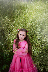 Little girl in pink dress look at camera